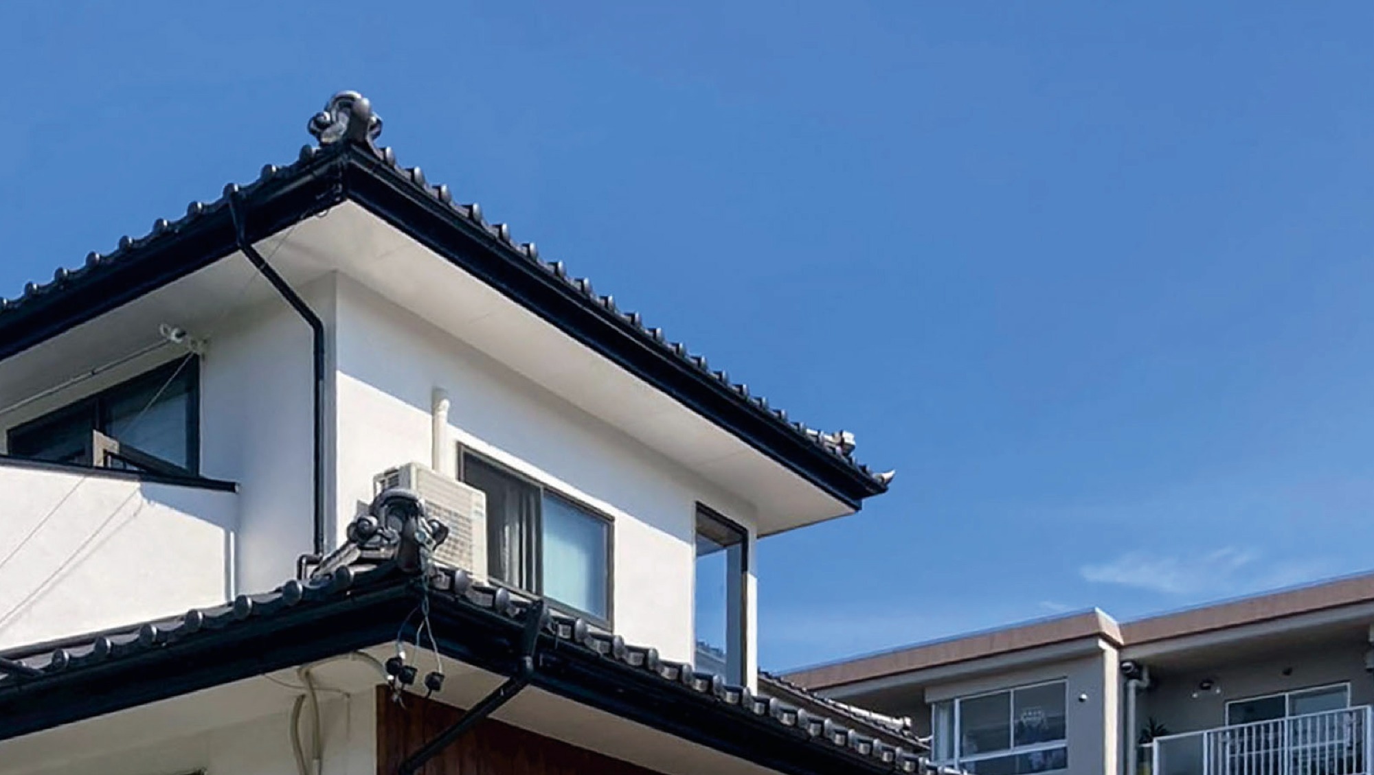 松本市S様邸の中古住宅リフォーム施工事例。青空に映える白い外壁の2階建て一軒家の外観写真